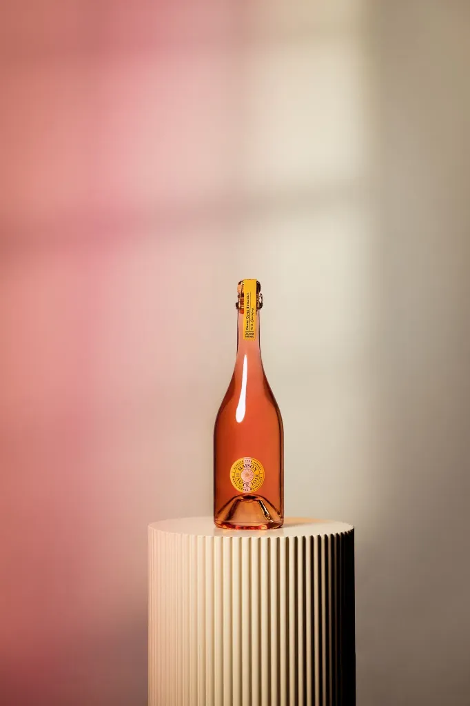 Grand Cuvée Botanique Rosé Sparkling 740 ml – bottle and glass in a pink setting